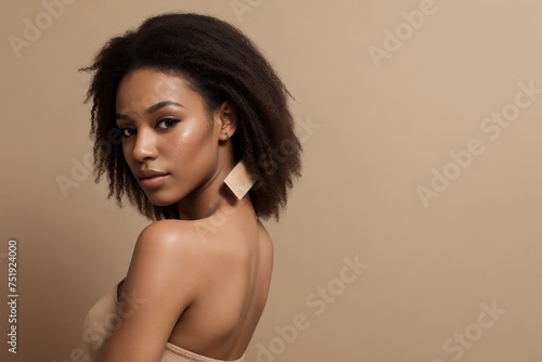 Young black woman model posing on a beige background with copy space for advertisement. 