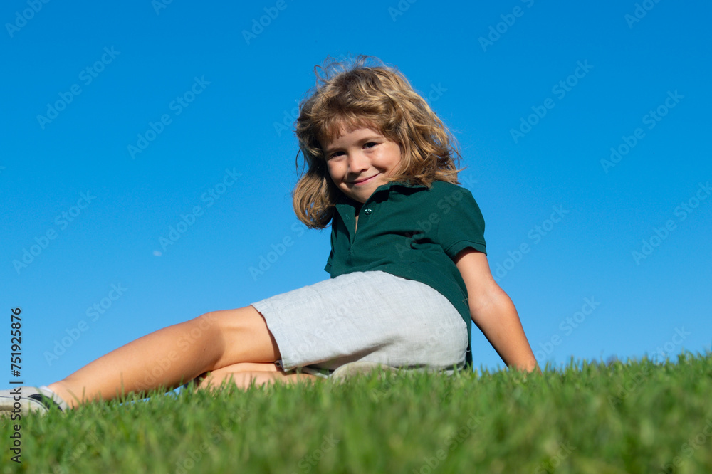Portrait of a smiling child lying on green grass. Cute kid boy enjoying nature outdoors. Healthy carefree kid playing outside in summer park. Healthy kids outdoor lifestyle concept. Portrait of a smiling child lying on green grass. Cute kid boy enjoying nature outdoors. Healthy carefree kid playing outside in summer park. Healthy kids outdoor lifestyle concept.