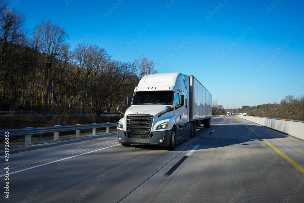 White 18 wheeler semi truck driving on the road	