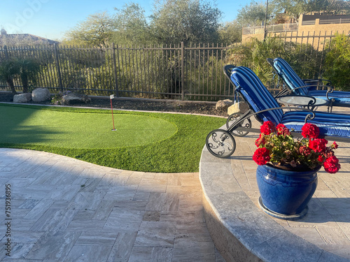 A Artificial putting green in a desert landscaped backyard.