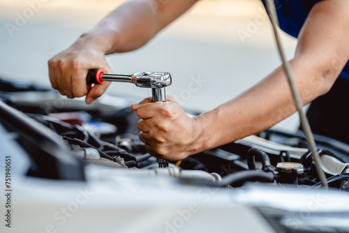 Close up of view Auto mechanic repairman using a socket wrench working engine repair in the garage, changing spare parts, checking the mileage of the car, checking and maintenance service concept.