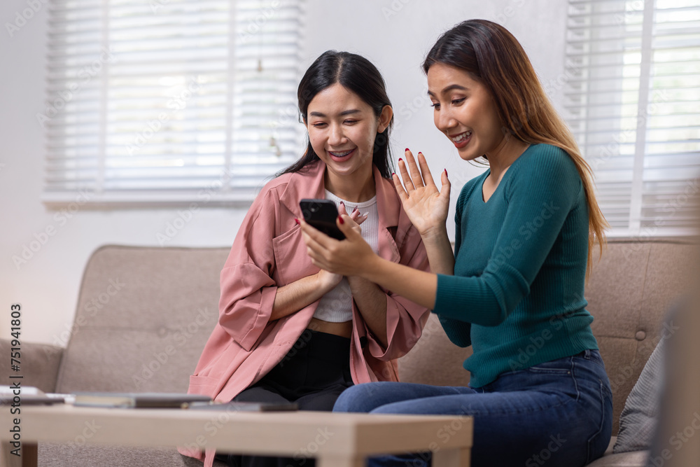 Two Asian women communicate with their friends and classmates via video link using a laptop and smartphone in the living room. Friends, friendship, happy time together Two Asian women communicate with their friends and classmates via video link using a laptop and smartphone in the living room. Friends, friendship, happy time together