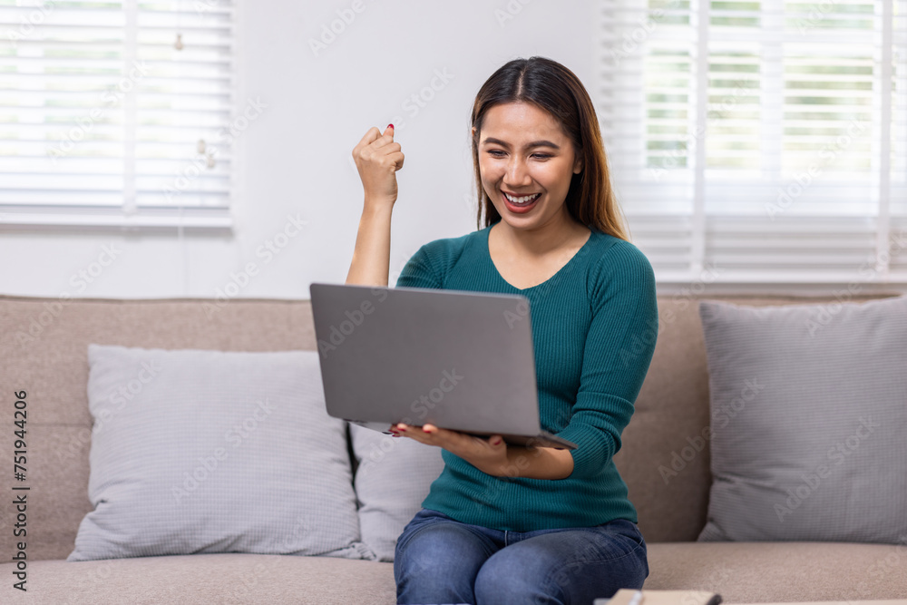 Happy young asian woman relax on comfortable couch at home texting messaging on laptop smartphone, smiling girl use cellphone chatting, browse wireless internet on gadget, work online from home Happy young asian woman relax on comfortable couch at home texting messaging on laptop smartphone, smiling girl use cellphone chatting, browse wireless internet on gadget, work online from home