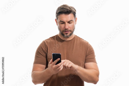 Handsome business man talking on phone. Businessman in casual clothes using smart phone isolated over studio background. Portrait of cheerful guy using cell phone, browse social media on phone. © Volodymyr