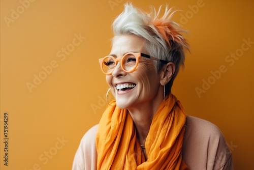 Portrait of a happy senior woman in orange glasses and orange scarf