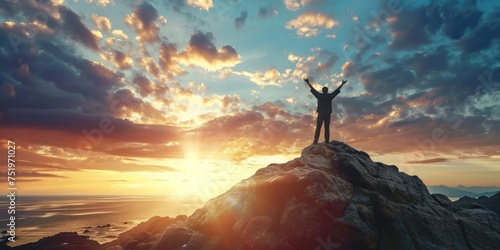 Silhouette of a man standing at the top of mountain with stretching arm up, success concept  photo