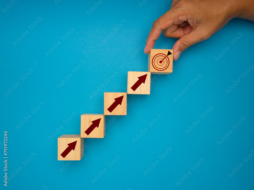 Hand holding a wooden cube with a target icon. Focus on a goal and achieve a successful business concept Hand holding a wooden cube with a target icon. Focus on a goal and achieve a successful business concept