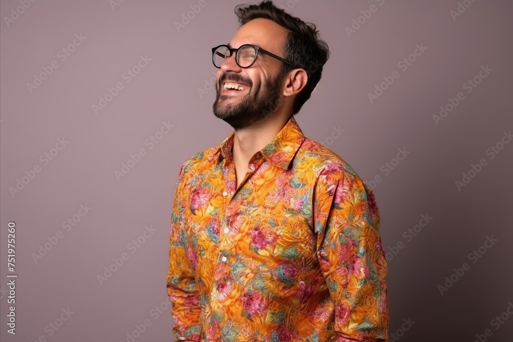 Handsome man with glasses and floral shirt smiling on purple background Handsome man with glasses and floral shirt smiling on purple background