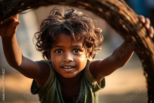 A Dalit child, around 5-6 years old, engaged in play. The child's clothing is simple, possibly hand-me-downs, yet the joy and innocence in their eyes reflect the universal spirit of child photo