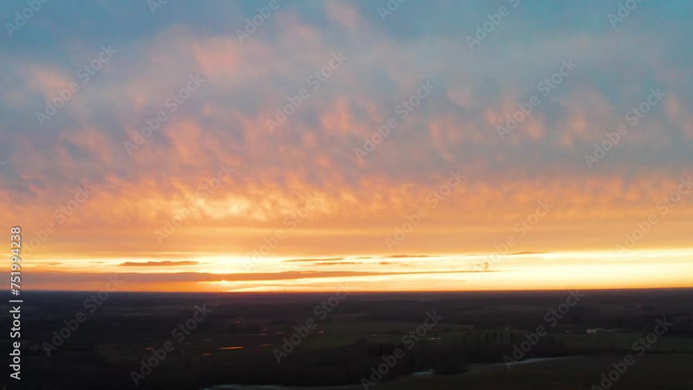 Aerial view of dark land during impressive golden hour sunset with clouds Aerial view of dark land during impressive golden hour sunset with clouds