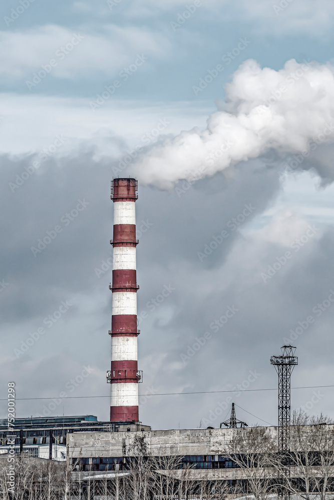 Factory chimney on a cloudy winter day