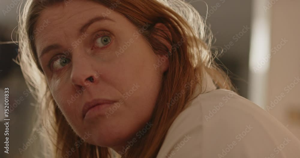 Woman in living room suddenly looking up to a sound Woman in living room suddenly looking up to a sound