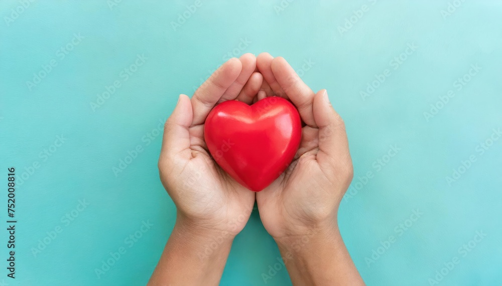 hands holding red heart on aqua background, heart health, donation, CSR concept, world heart hands holding red heart on aqua background, heart health, donation, CSR concept, world heart