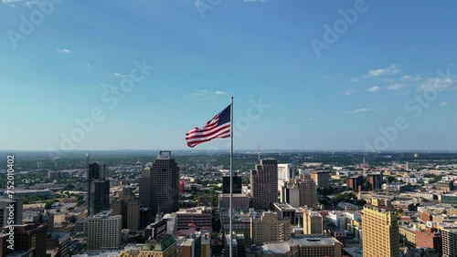 Aerial tilt-up US flag flying proudly atop the Tower Life Building in San Antonio photo