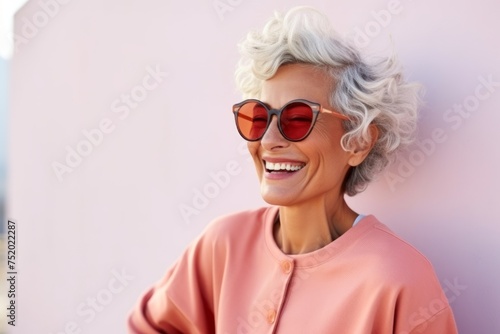 summer, fashion, people and lifestyle concept - smiling senior woman in sunglasses over pink background