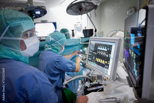 Female surgeons examining medical report on computer at hospital photo