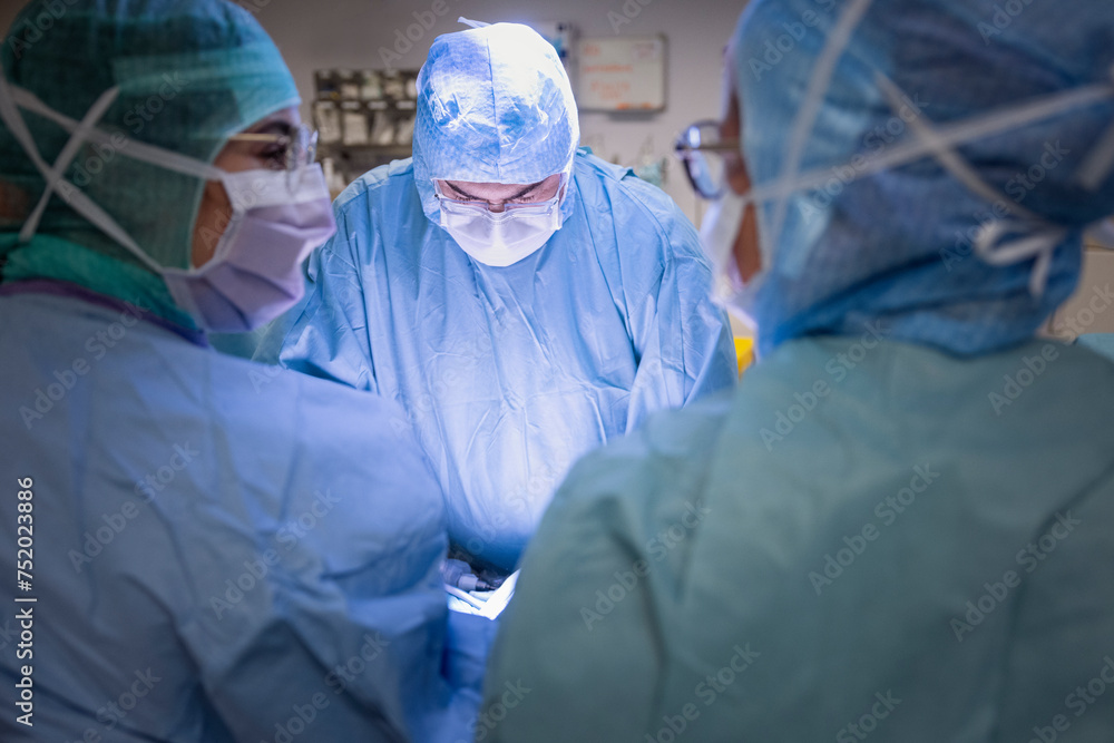Doctors wearing surgical masks while doing surgery in operation theater Doctors wearing surgical masks while doing surgery in operation theater