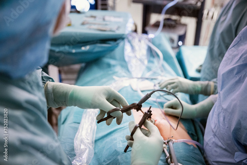 Midsection of surgeons doing abdomen surgery of patient in operation theater at hospital photo