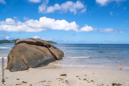 Granite gray rocks on the famous beach of Louis Coco with blue tropical water and amazing sky in Mahe Island. Seychelles