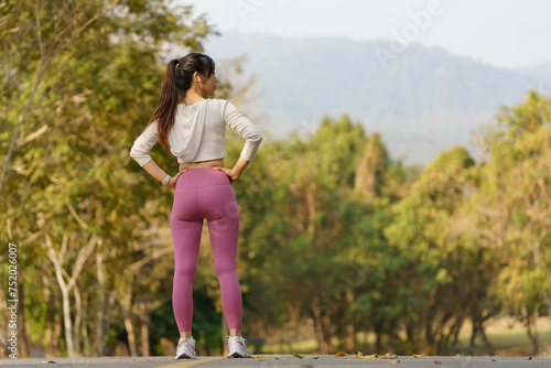 Young female runner stretching arms before running in the morning. Women stretch to warm up before running or working out. Fitness and healthy lifestyle concept.