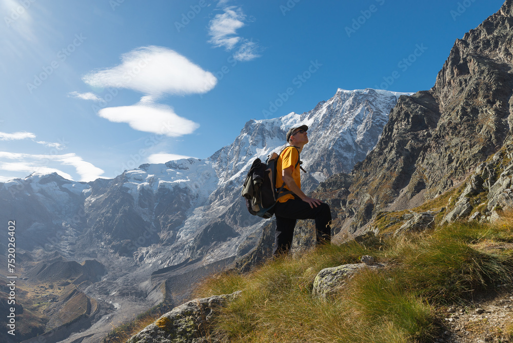 Obraz premium High mountain hiker with a glacier in the background, European Alps and the spectacular east wall of Monte Rosa (4636 m). Ascent to the Sella bivouac, Macugnaga, Italy. Outdoor activities