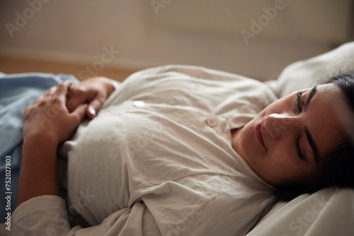Young female patient lying on bed in ward at hospital photo