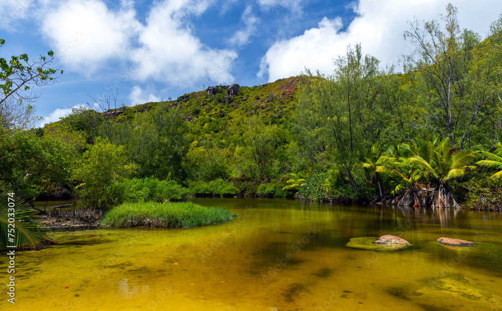 Landscape with rocks and a lake on a sunny day. Anse Lazio beach