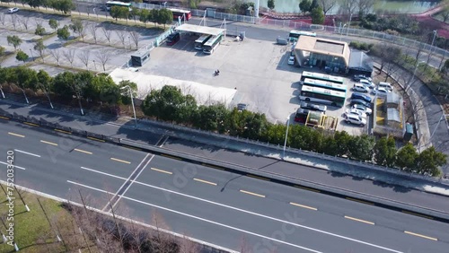 Aerial view of electric bus station near highway, technology advancement, clean energy urban area