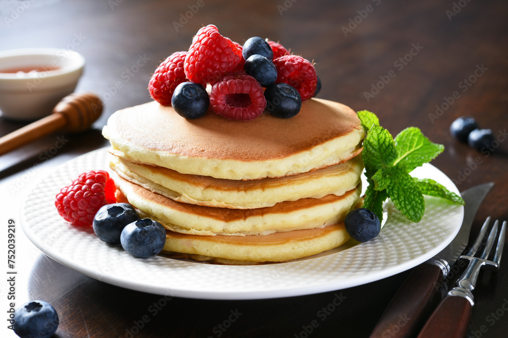 Pancakes with raspberries and blueberries with honey. Morning,pancakes for breakfast Pancakes with raspberries and blueberries with honey. Morning,pancakes for breakfast