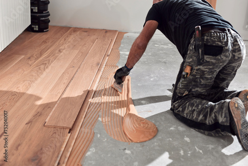 Professional handyman installing laminate flooring in a new apartment.