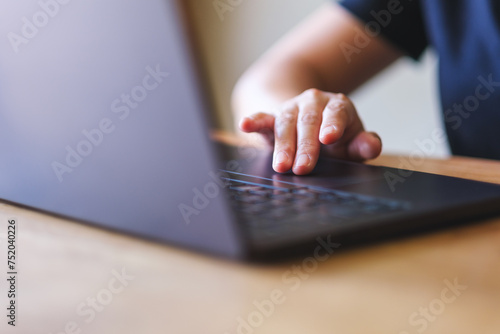 Closeup image of a hand working and touching on laptop computer touchpad