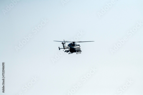 Fototapeta Naklejka Na Ścianę i Meble -  A helicopter is flying away on isolated blue sky