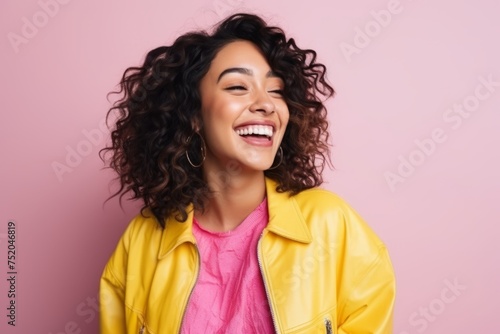 Portrait of a beautiful young african american woman laughing against pink background