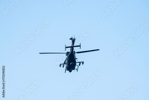 A helicopter is flying away on isolated blue sky