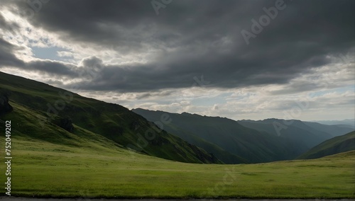 Grassy field near a grassy mountain under a cloudy sky