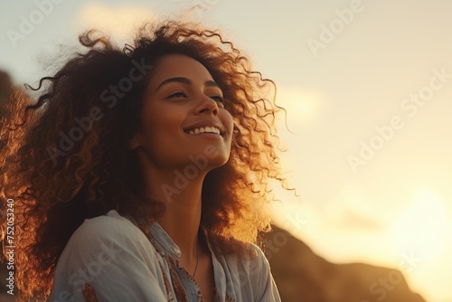 Woman with curly hair smiling and looking up at the sky. Suitable for lifestyle and happiness concepts © Fotograf