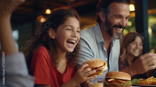A man and a little girl eating a hamburger. Perfect for family mealtime concepts photo
