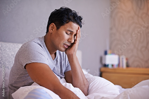 Man, sad and frustrated in bedroom with problem, disappointment and upset with mental health in morning. Young person, unhappy face and headache on weekend with depression and tired on bed in house