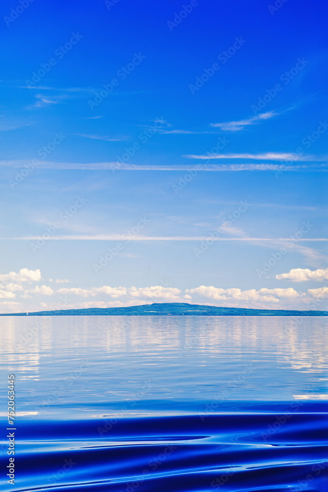 Obraz premium Wave pattern on lake Vänern with the hill Kinnekulle on a beautiful sunny summer day in Sweden