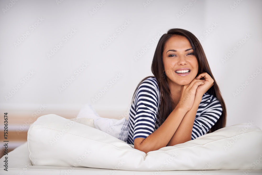 Smile, resting and portrait of woman on sofa in living room with positive, pride or confident attitude. Happy, calm and young female person relaxing on couch in lounge on weekend in modern apartment. Smile, resting and portrait of woman on sofa in living room with positive, pride or confident attitude. Happy, calm and young female person relaxing on couch in lounge on weekend in modern apartment.