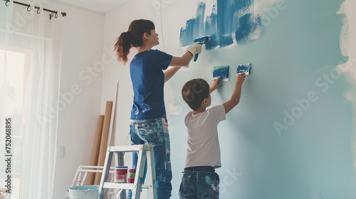 Mother and son painting the wall for home improvement in the living room photo