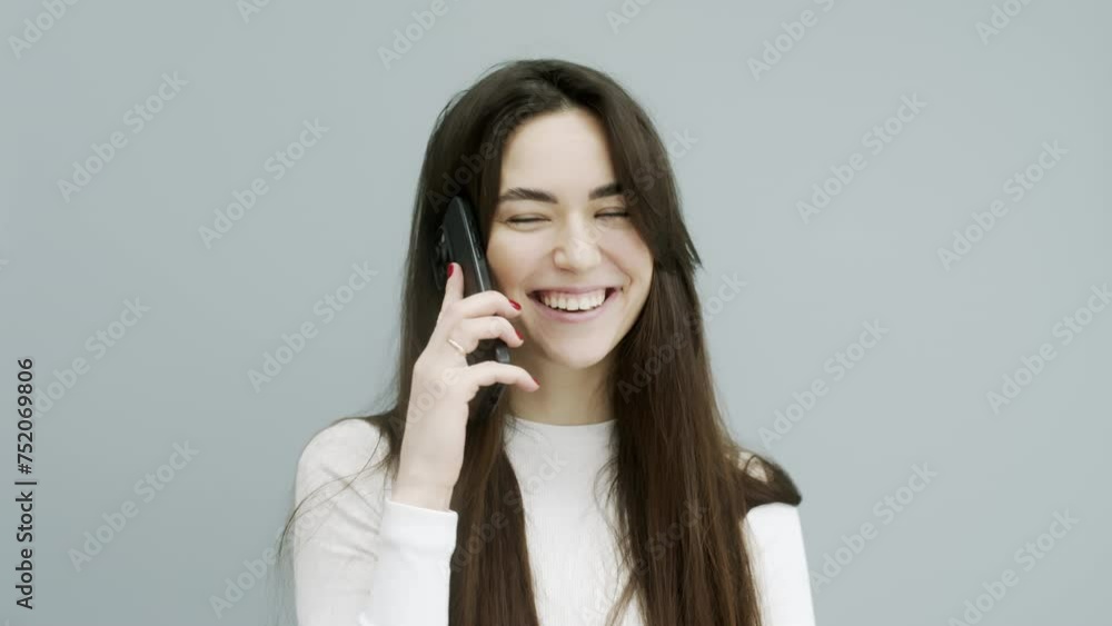 Cheerful Asian woman over isolated background talking on the phone. Concept of online support, online communication, modern technologies. Cheerful Asian woman over isolated background talking on the phone. Concept of online support, online communication, modern technologies.