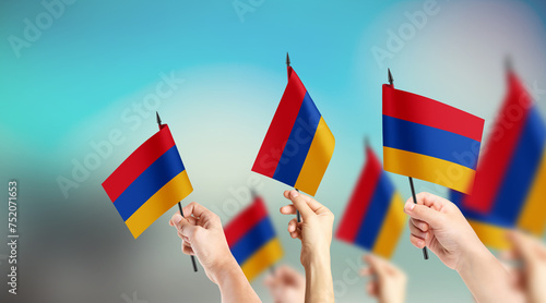 Fototapeta Naklejka Na Ścianę i Meble -  A group of people are holding small flags of Armenia in their hands.