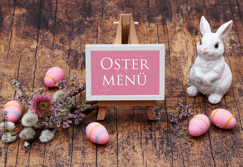 Der Text Osterbrunch auf ein Schild geschrieben mit Osterdekoration und Blumen. 