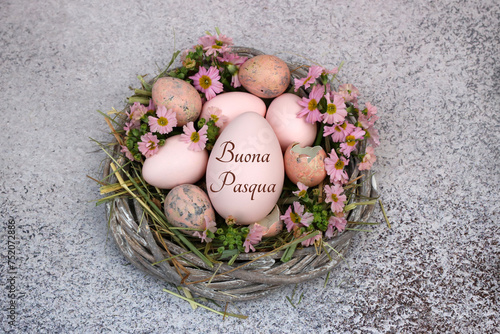 Frohe Ostern: Beschriftetes Osterei mit Blumen und Wachteleiern in einem Nest. photo