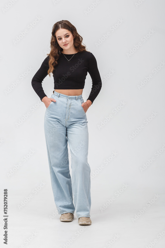 girl model in black shirt and blue trousers jeans posing relaxed in studio girl model in black shirt and blue trousers jeans posing relaxed in studio