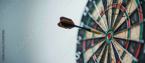 A red arrow is shot at a target with the numbers 1 through 12 on the side. Concept of competition and focus as the arrow is aimed at the target photo