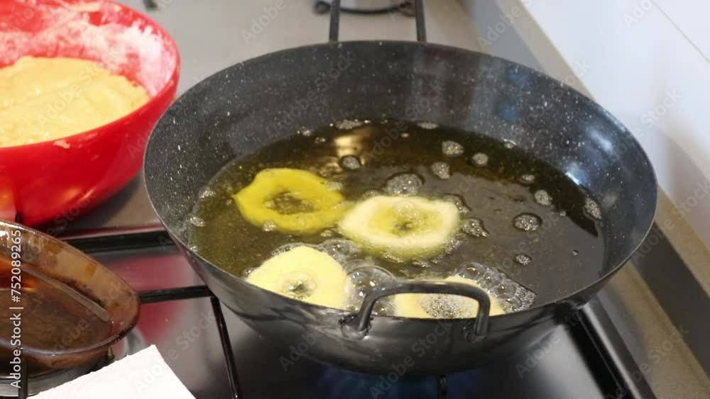 Hands of a middle-aged woman forming the donut dough and frying them in hot oil to prepare a typical recipe of a village in Andalusia, Spain. Hands of a middle-aged woman forming the donut dough and frying them in hot oil to prepare a typical recipe of a village in Andalusia, Spain.