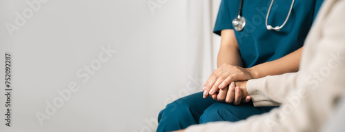A female nurse caregiver holds hands to encourage and comfort an elderly woman. For care and trust in nursing homes for people of retirement age Caregiver helping elderly woman provides medical advice