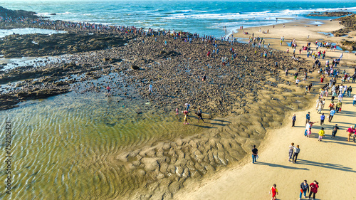 Aerial view of Hon Ba island in Vung Tau city, Vietnam. On full moon day of lunar calendar, when tide is low, people can walk across island to visit temple on mountain. Spiritual travel concept. photo